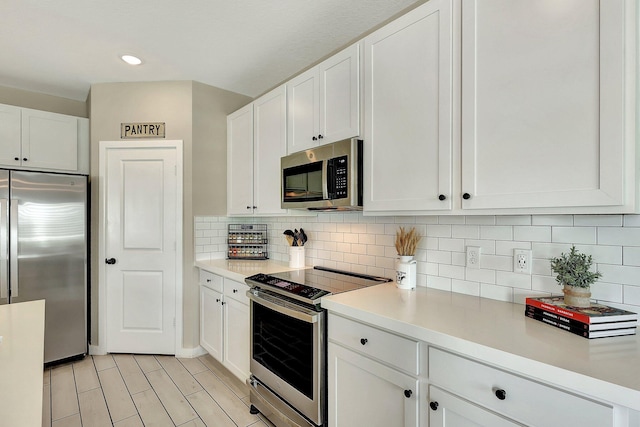 kitchen featuring white cabinetry, appliances with stainless steel finishes, and light countertops