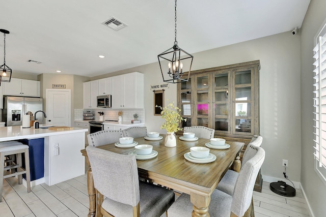 dining space featuring a chandelier, visible vents, plenty of natural light, and baseboards