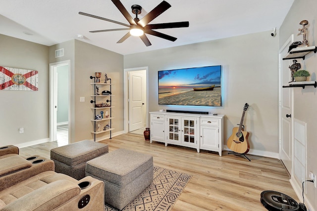 living room featuring light wood-style floors, baseboards, visible vents, and ceiling fan