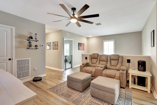 living room with visible vents, light wood-style flooring, and baseboards