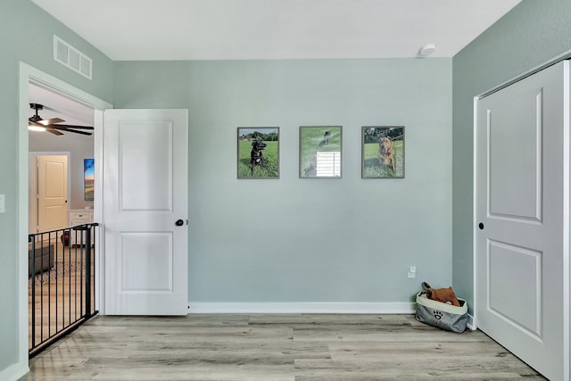 interior space featuring light wood-type flooring, visible vents, and baseboards