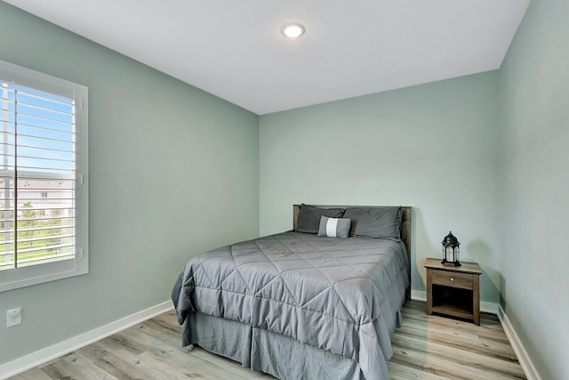 bedroom with baseboards and wood finished floors