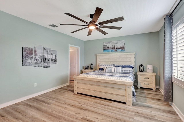 bedroom featuring baseboards, multiple windows, and light wood finished floors