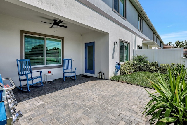 view of patio featuring ceiling fan and fence