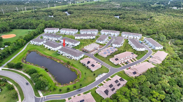 drone / aerial view featuring a residential view, a water view, and a view of trees