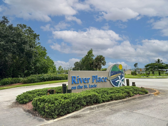 community / neighborhood sign featuring uncovered parking