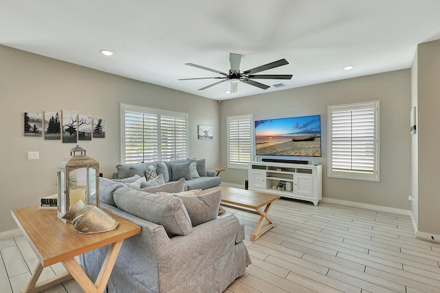 living room with ceiling fan, baseboards, light wood-style flooring, and recessed lighting