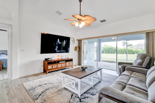 living room featuring lofted ceiling, ceiling fan, wood finished floors, and visible vents