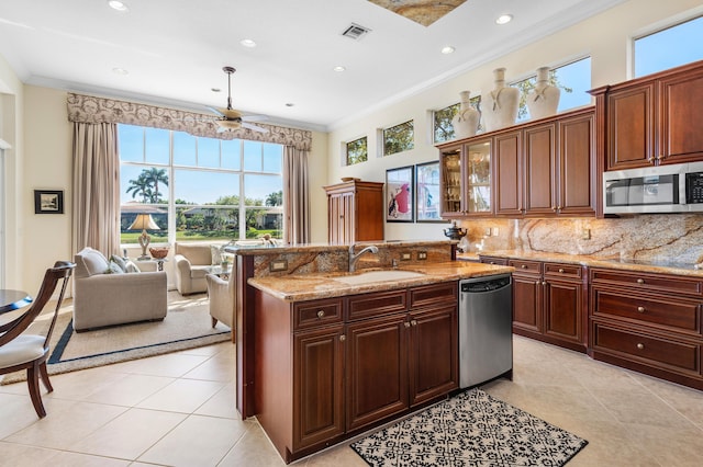 kitchen featuring stainless steel appliances, a sink, visible vents, and crown molding