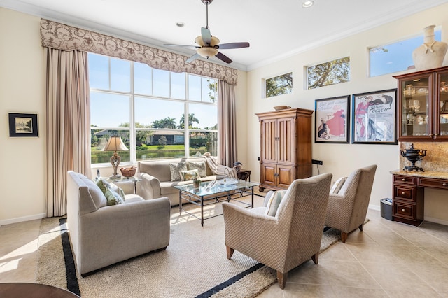 living room featuring light tile patterned floors, baseboards, a ceiling fan, ornamental molding, and a high ceiling