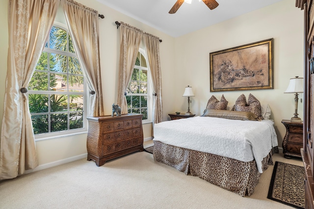 carpeted bedroom featuring ceiling fan, multiple windows, and baseboards