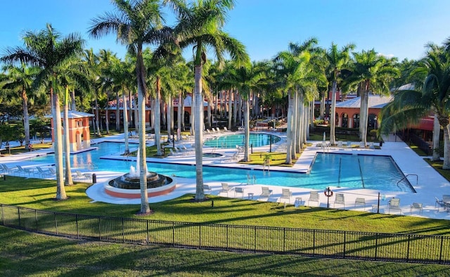 community pool with fence and a lawn