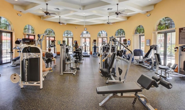 gym with french doors, coffered ceiling, and a high ceiling