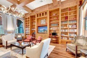 living area with beam ceiling, coffered ceiling, and wood finished floors