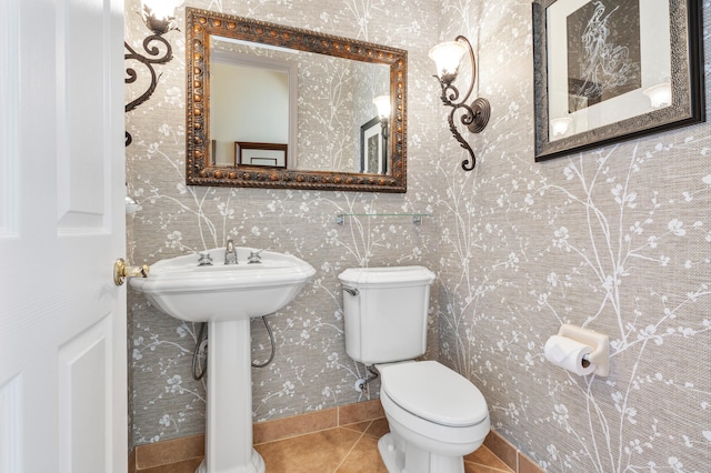 bathroom with wallpapered walls, toilet, and tile patterned floors