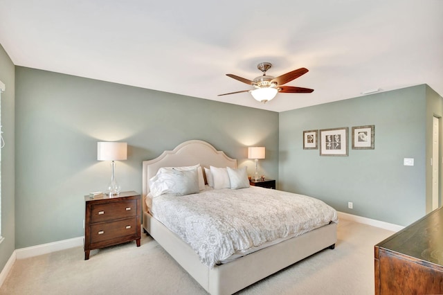 bedroom featuring light colored carpet, ceiling fan, and baseboards