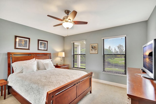 bedroom featuring a ceiling fan, light carpet, and baseboards