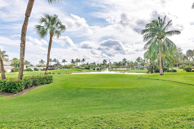 view of property's community featuring a yard, a water view, and view of golf course