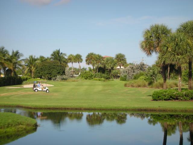 view of home's community with a water view, golf course view, and a yard