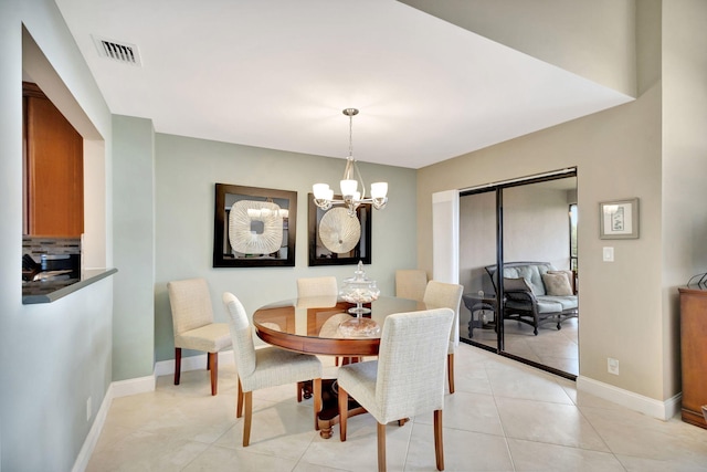 dining space with baseboards, light tile patterned floors, visible vents, and an inviting chandelier