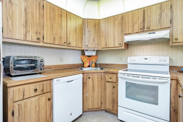 kitchen featuring light tile patterned flooring, sink, butcher block countertops, and white appliances