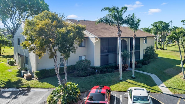 view of front of home featuring a front yard and cooling unit