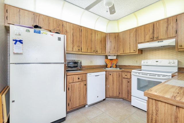 kitchen with light tile patterned flooring, sink, a textured ceiling, ceiling fan, and white appliances