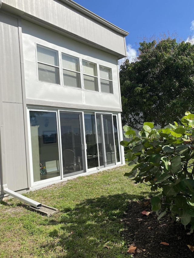 view of side of home with a yard