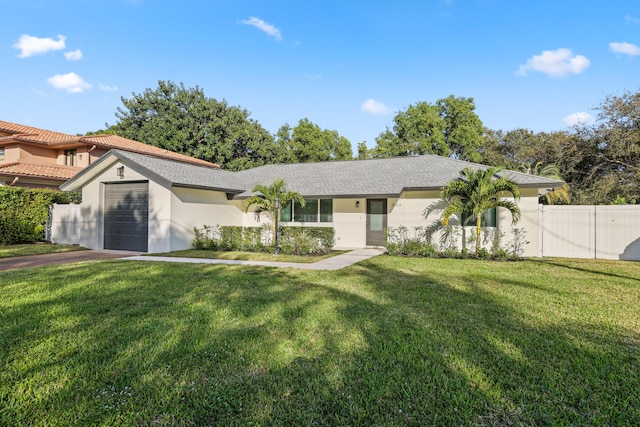 view of front of property featuring stucco siding, fence, a garage, driveway, and a front lawn