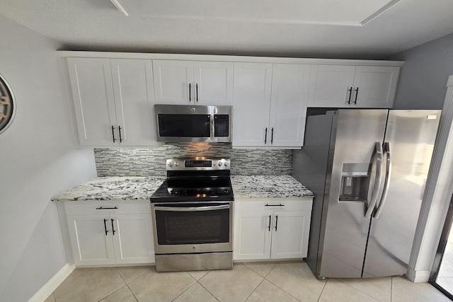 kitchen featuring backsplash, white cabinets, light stone countertops, and stainless steel appliances