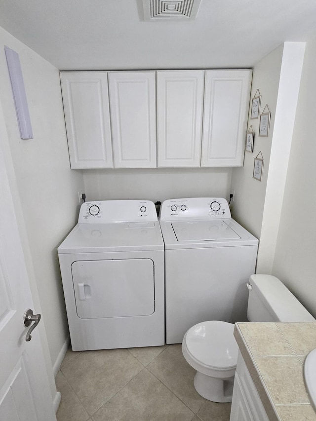 clothes washing area with separate washer and dryer and light tile patterned floors