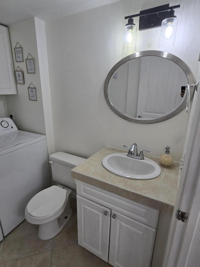 bathroom featuring vanity, toilet, tile patterned floors, and washer / dryer