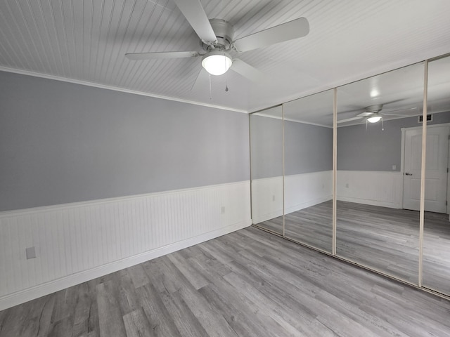 spare room with light hardwood / wood-style floors, ceiling fan, and ornamental molding