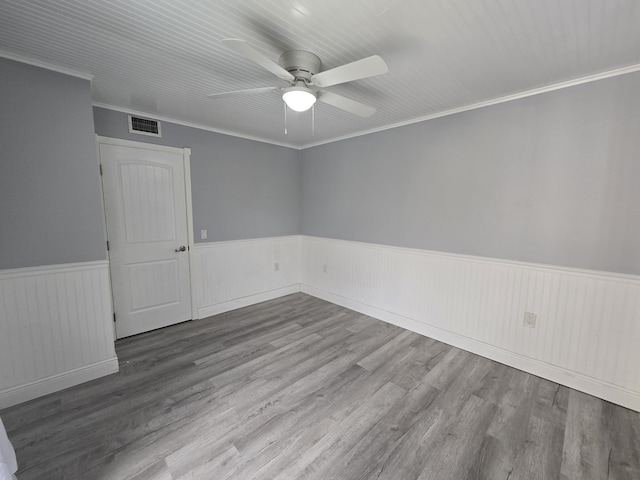 unfurnished room with hardwood / wood-style floors, crown molding, and ceiling fan