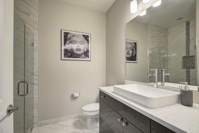 bathroom featuring vanity, a shower with door, and toilet