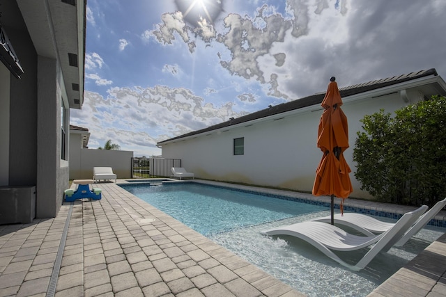 view of swimming pool featuring a patio area and an in ground hot tub