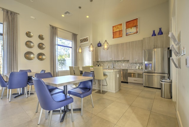 dining room with light tile patterned floors and a high ceiling