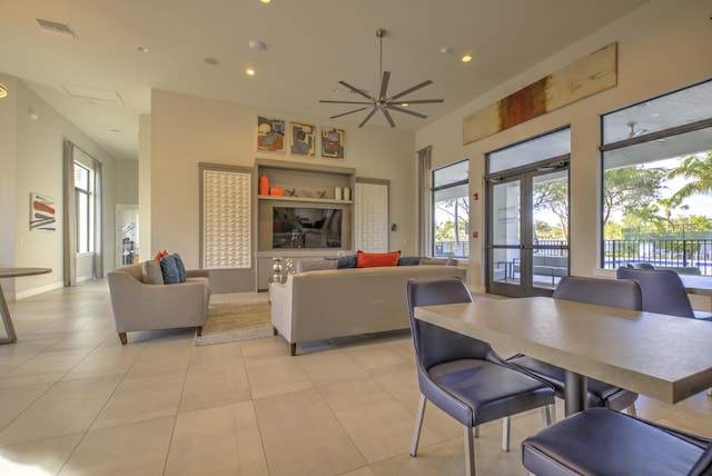 dining area with a healthy amount of sunlight, light tile patterned floors, ceiling fan, and french doors