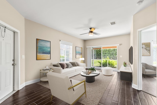 living area with a healthy amount of sunlight, wood tiled floor, visible vents, and baseboards