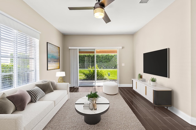 living room with a ceiling fan, wood tiled floor, visible vents, and baseboards