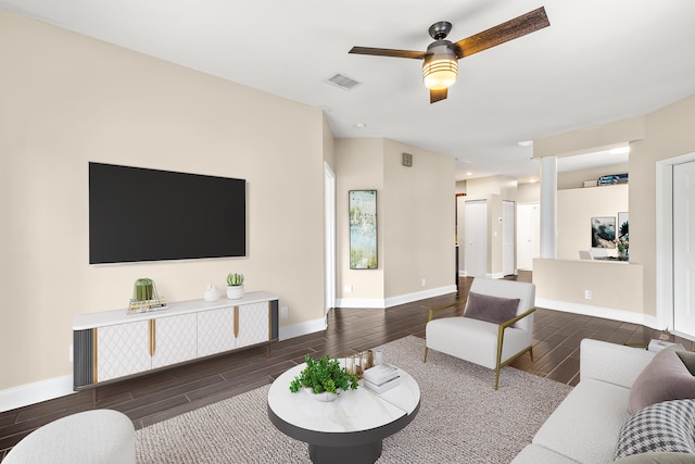 living room with wood finish floors, visible vents, ceiling fan, and baseboards