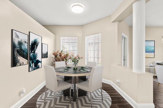 dining room with dark wood-type flooring, decorative columns, and baseboards