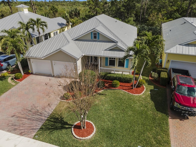 view of front of home featuring a porch, a garage, and a front lawn