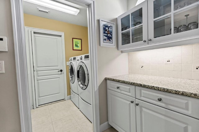 laundry area featuring light tile patterned floors and washing machine and clothes dryer