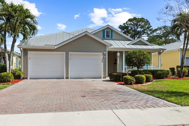 view of front of property featuring a garage, a porch, and a front yard