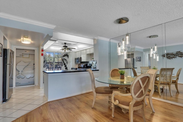 dining room with ceiling fan, ornamental molding, a textured ceiling, and light hardwood / wood-style floors