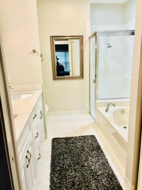 full bathroom featuring vanity, a shower stall, a garden tub, and tile patterned flooring