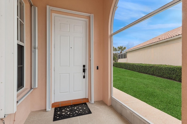 entrance to property with a lawn