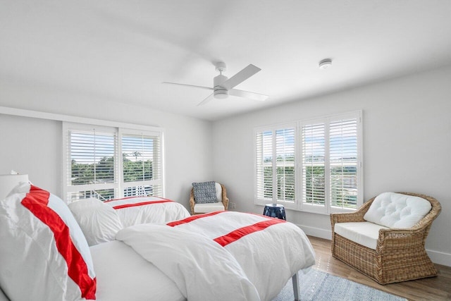 bedroom featuring wood finished floors, a ceiling fan, and baseboards