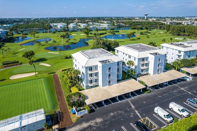 aerial view with golf course view and a water view